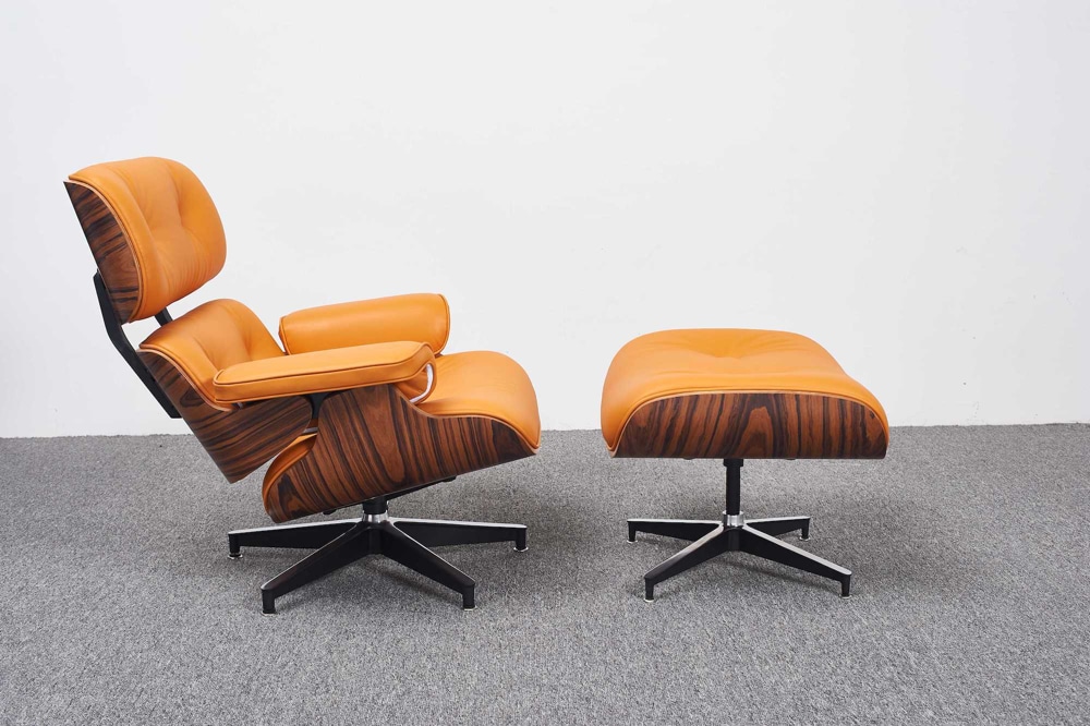 Kopie Charles Eames Sessel mit Ottoman italienischem Leder orange Palisanderholz schwarze Alu-Basis in einem Büro